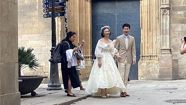 Ajena al caos del apagón, una pareja de recién casados, de origen chino, posan para el fotógrafo, en las proximidades de plaza Sant Jaume