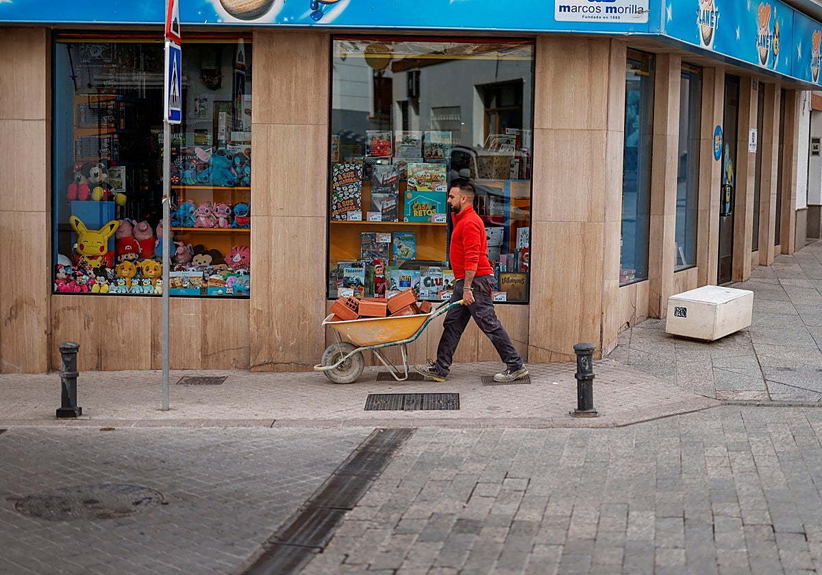 Un trabajador empujando una carretilla en Ronda