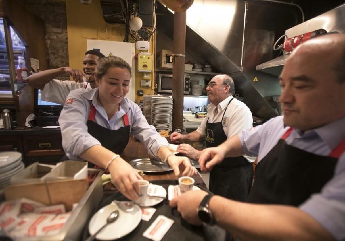 Varios camareros trabajando en un bar.