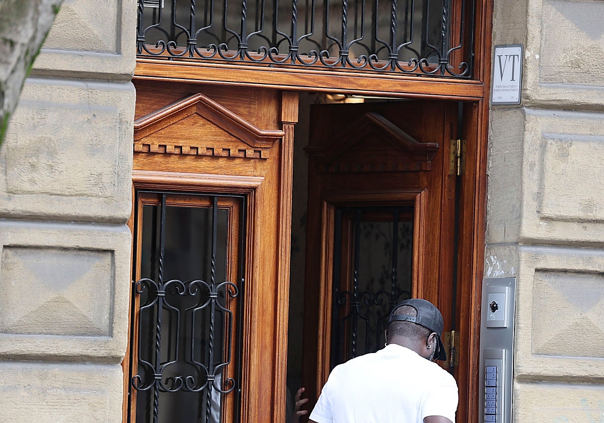 Una persona entra en un edificio de pisos turísticos