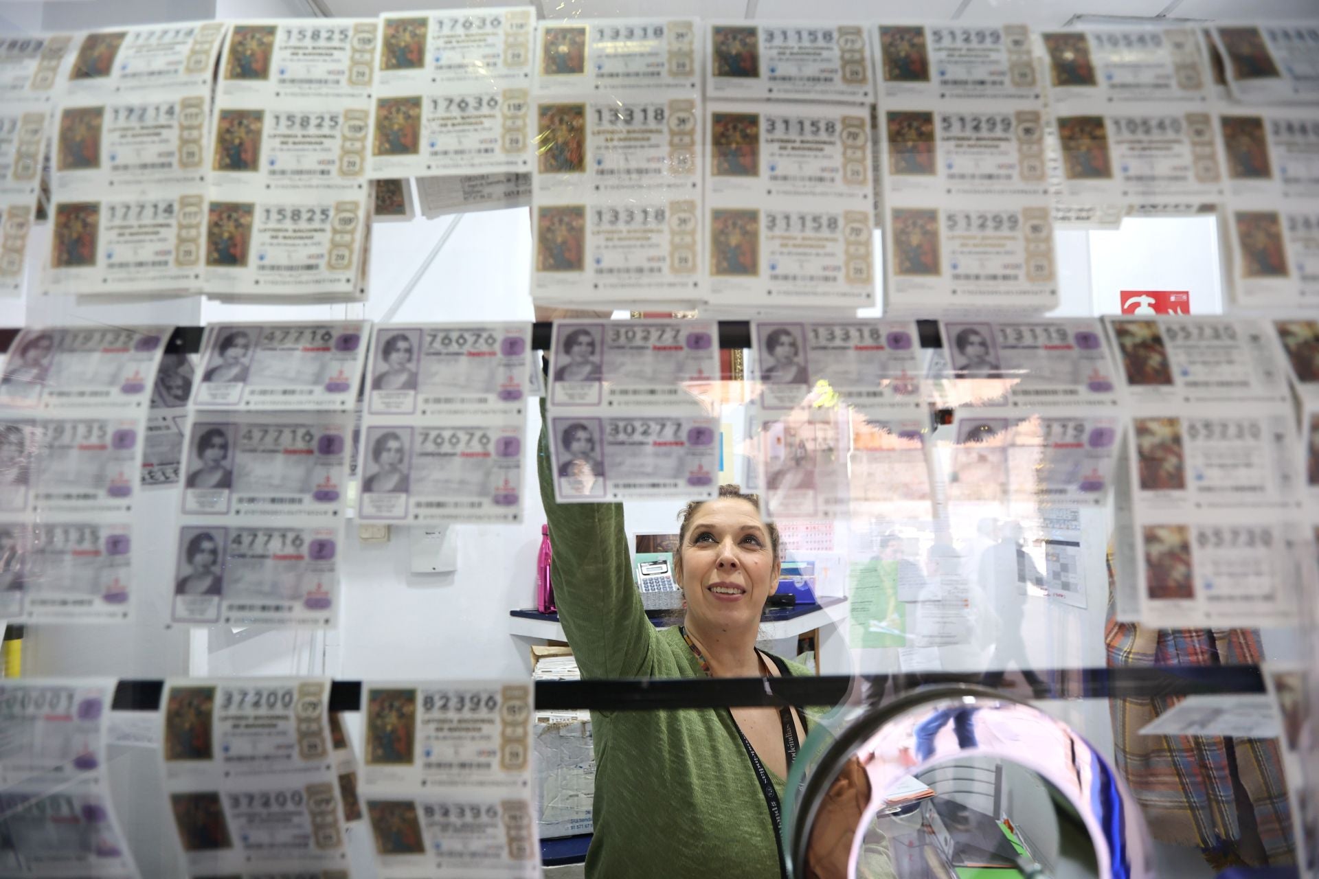 Una dependienta atiende en la administración San Rafael.