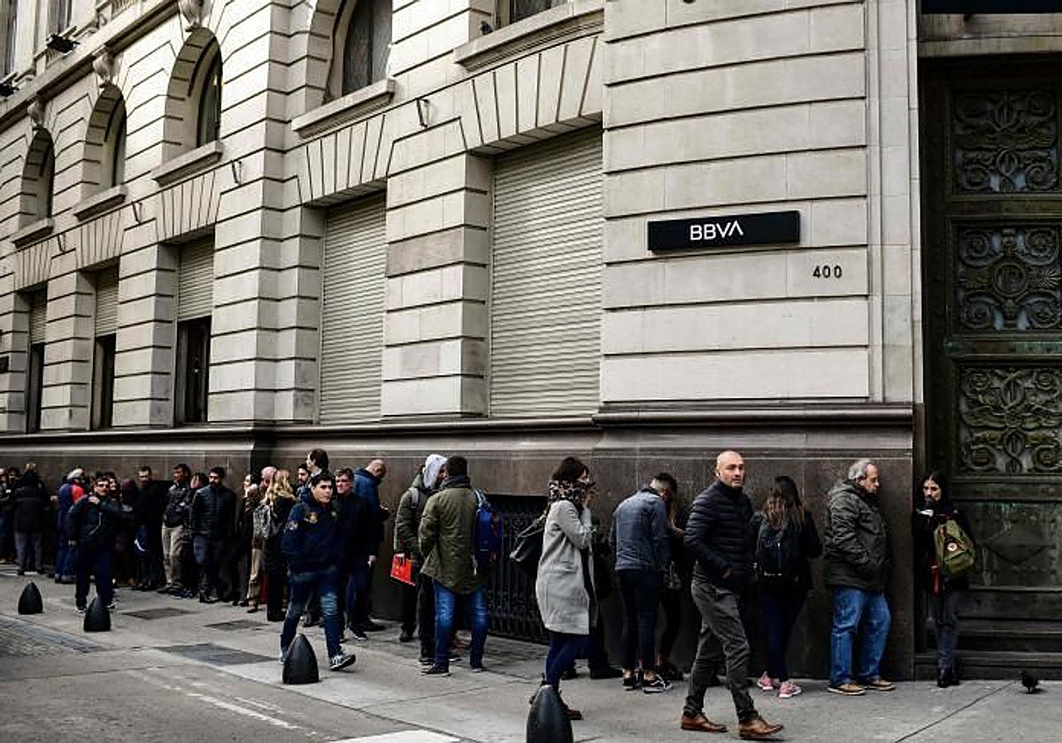 Personas hacen cola ante una oficina de BBVA en Buenos Aires