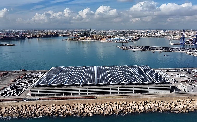 Imagen principal - Tres imágenes del puerto de Valencia: arriba, planta fotovoltaica. Sobre estas líneas, izquierda, una grúa carga remolques en un convoy ferroviario y, a la derecha máquina propulsado por hidrógeno verde para mover contenedores