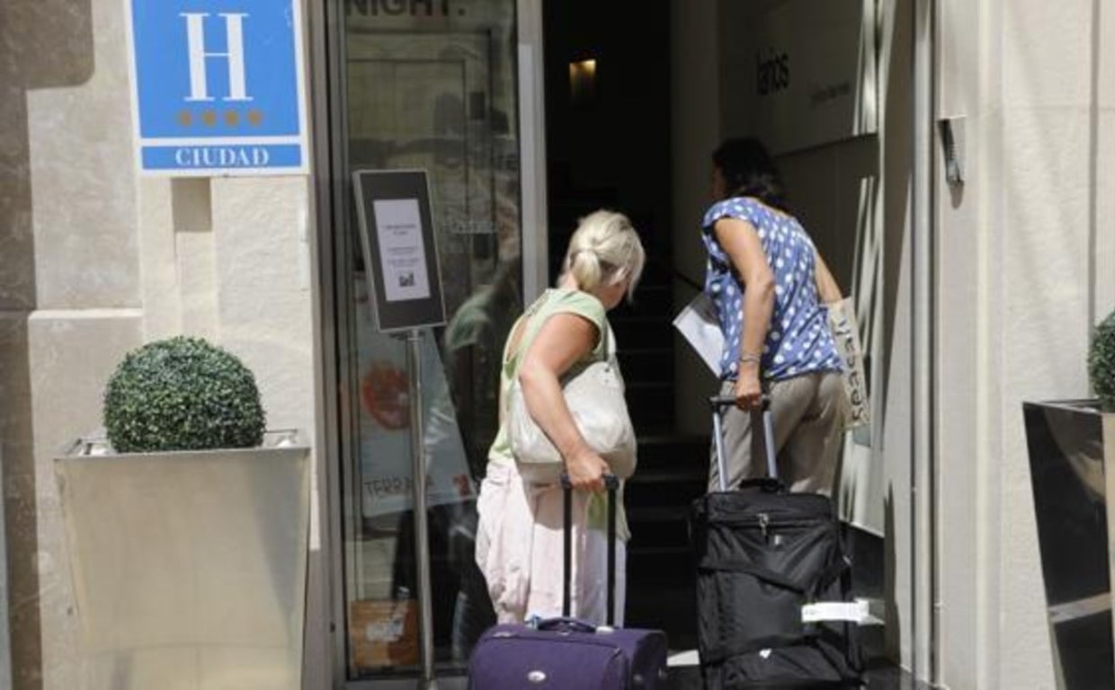 Dos turistas entran en un hotel de cuatro estrellas