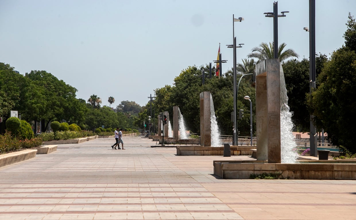 Dos personas por el solitario Paseo de Córdoba