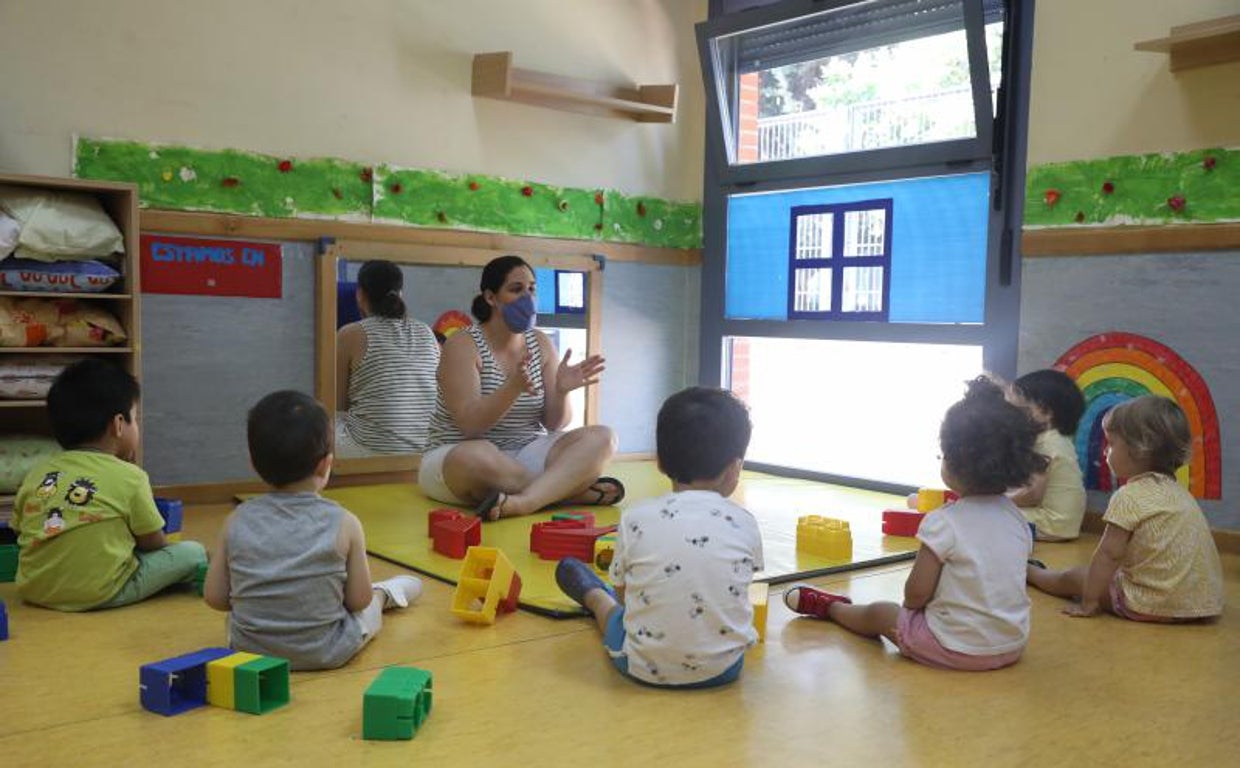 Una docente imparte clases a varios alumnos en la Escuela Infantil El Tren de la Fresa, en Madrid