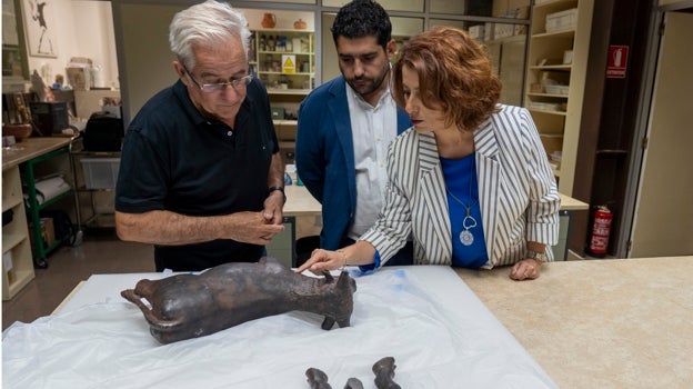 El director del Museo de Teruel, Jaime Vicente, el diputado provincial de Cultura, Diego Piñeiro y la alcadesa de Teruel, Emma Buj observan la figura dañada del Torico de Teruel