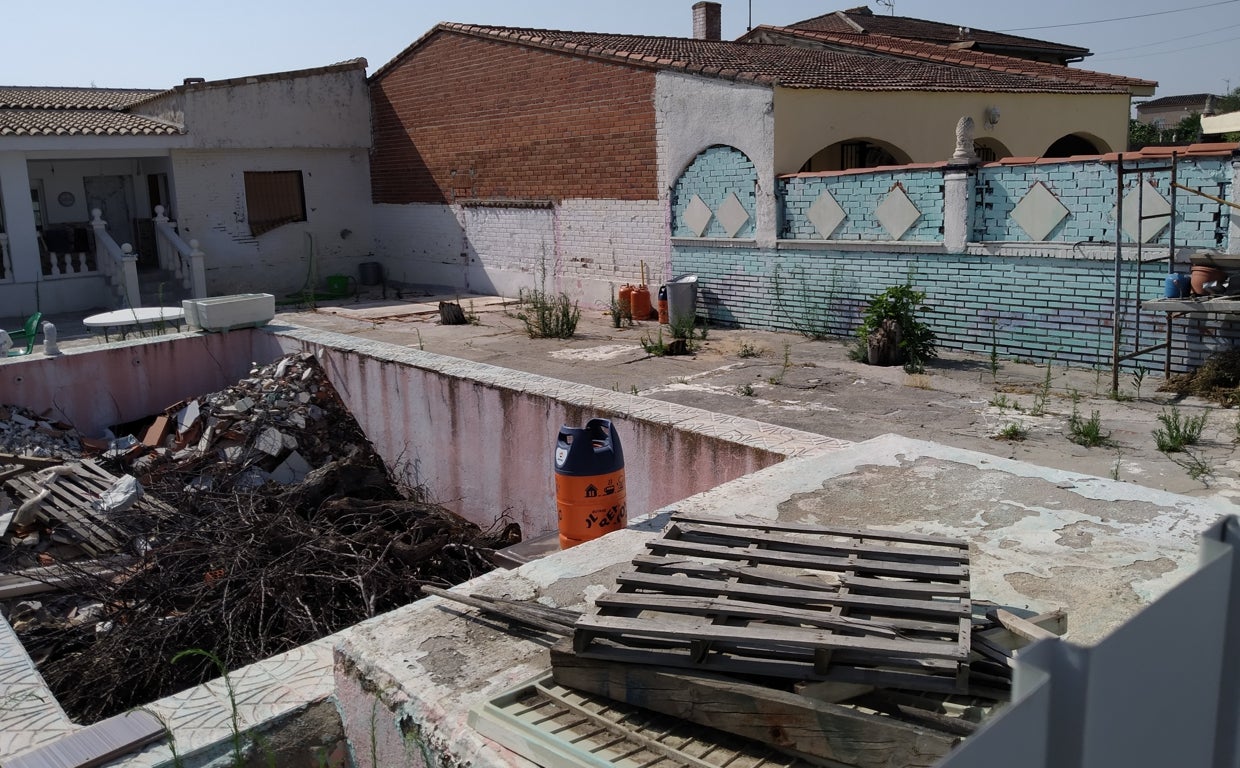 Interior del chalé donde Herminia vivía, este domingo. A la derecha, el domicilio donde reside el detenido. Los separaba el muro medianero