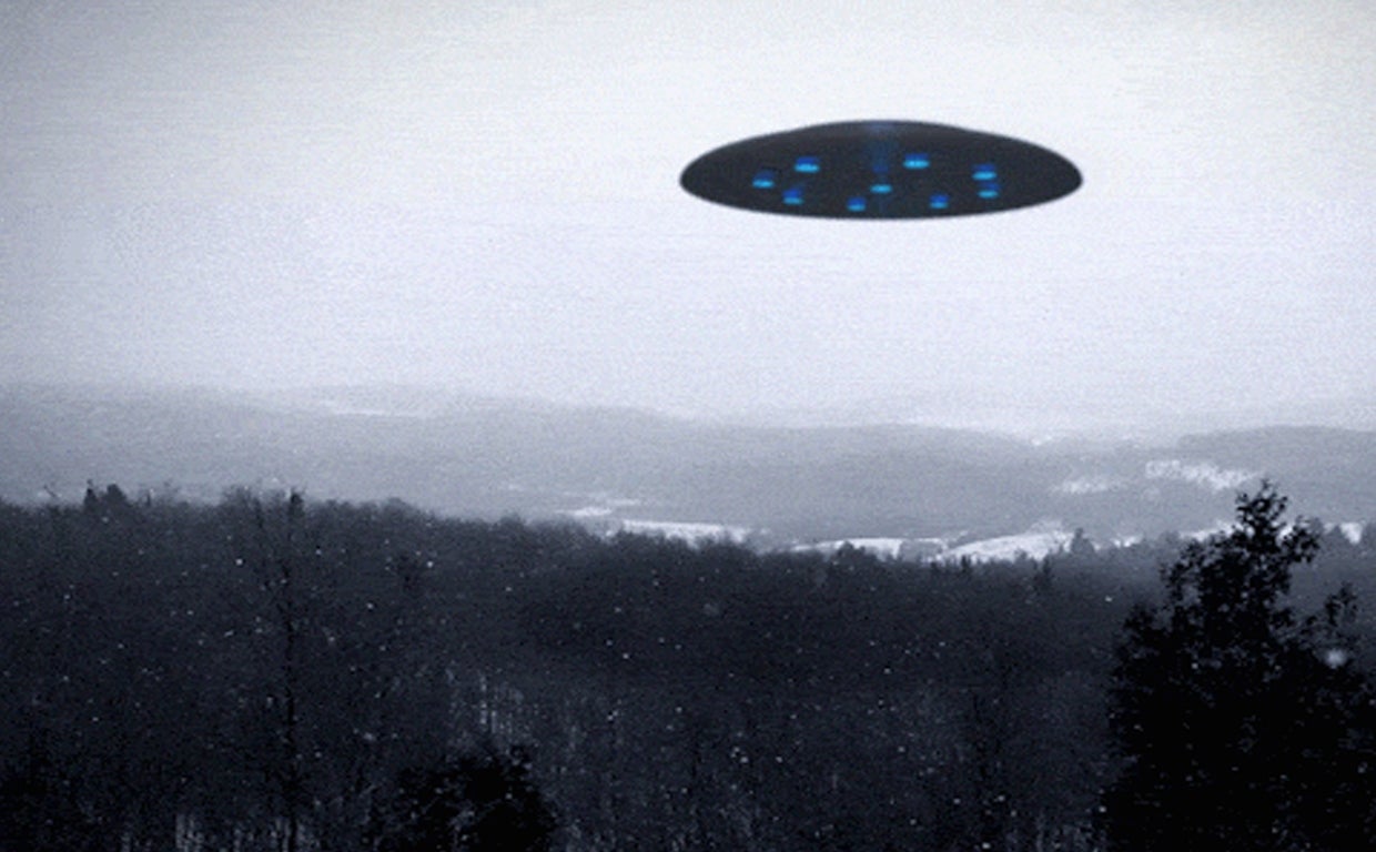 Montaje de un OVNI sobrevolando un bosque