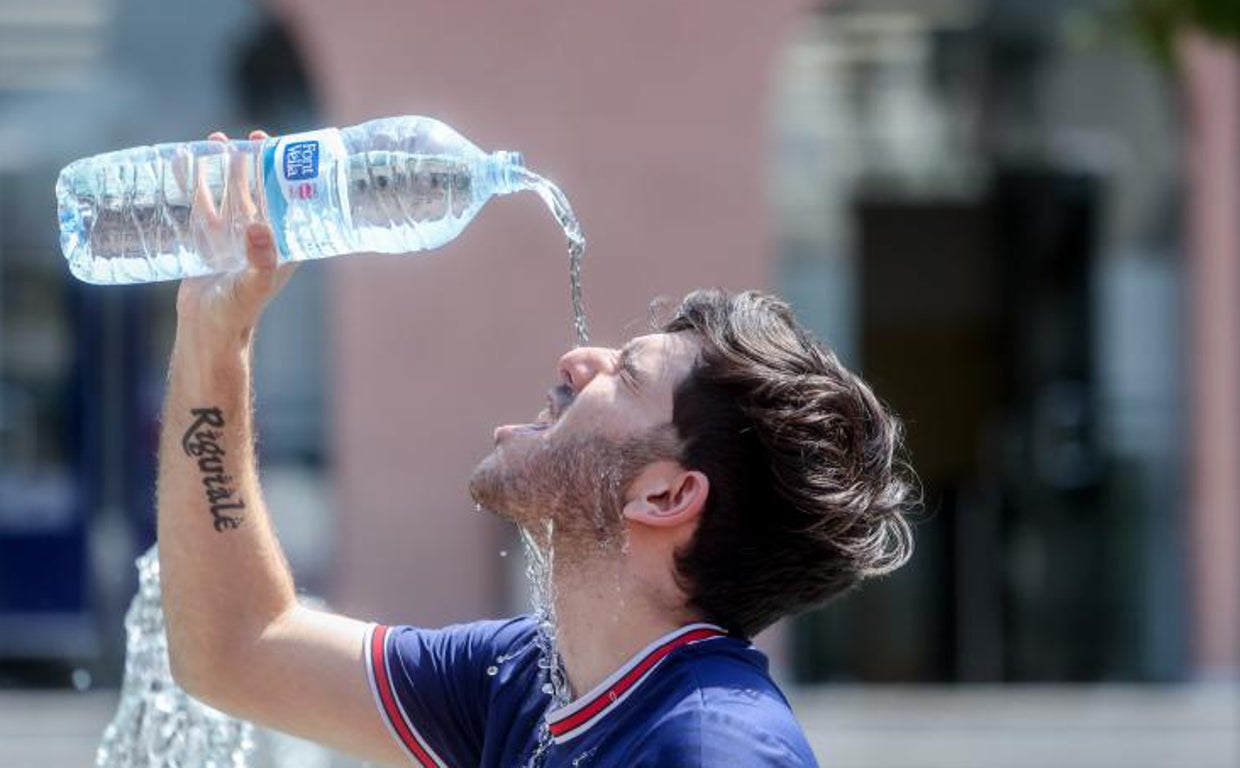 Un joven se refresca en plena segunda ola de calor en Madrid