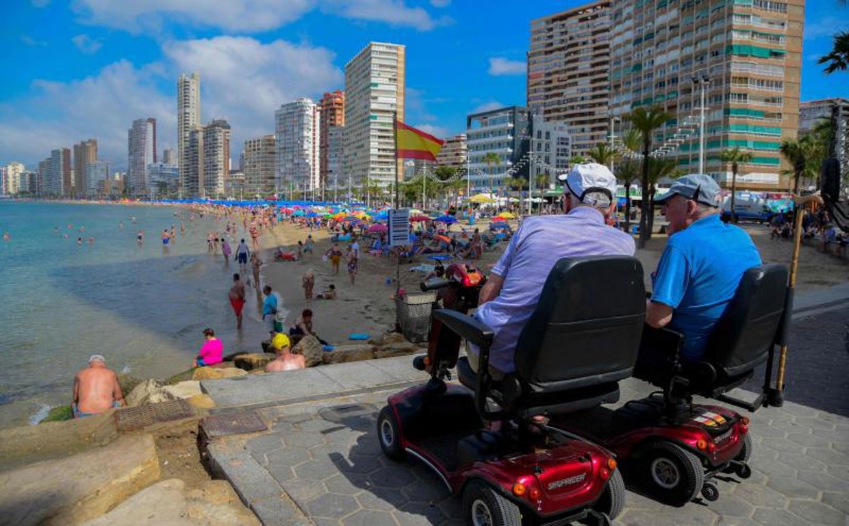 Dos turistas mayores observan la Playa de Levante de Benidorm