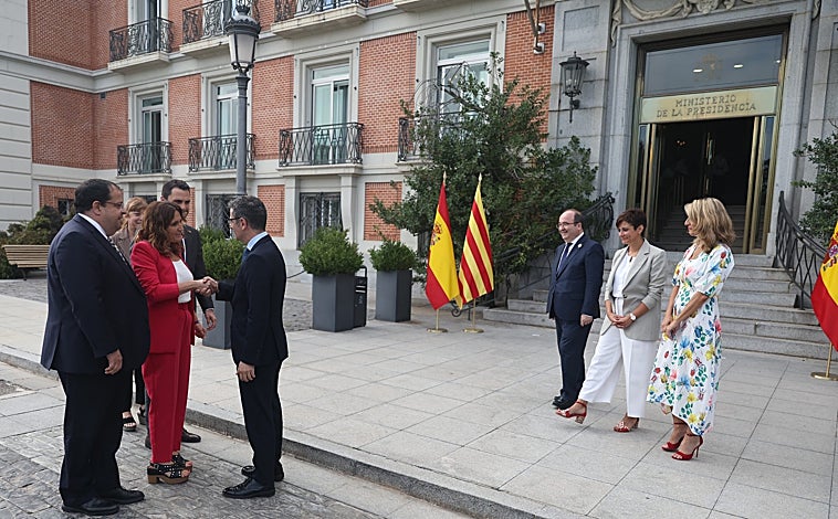 Imagen principal - Saludo y posado de ambas delegaciones en la puerta del Ministerio de Presidencia, tras el cual se han dirigido por parejas al lugar de la reunión