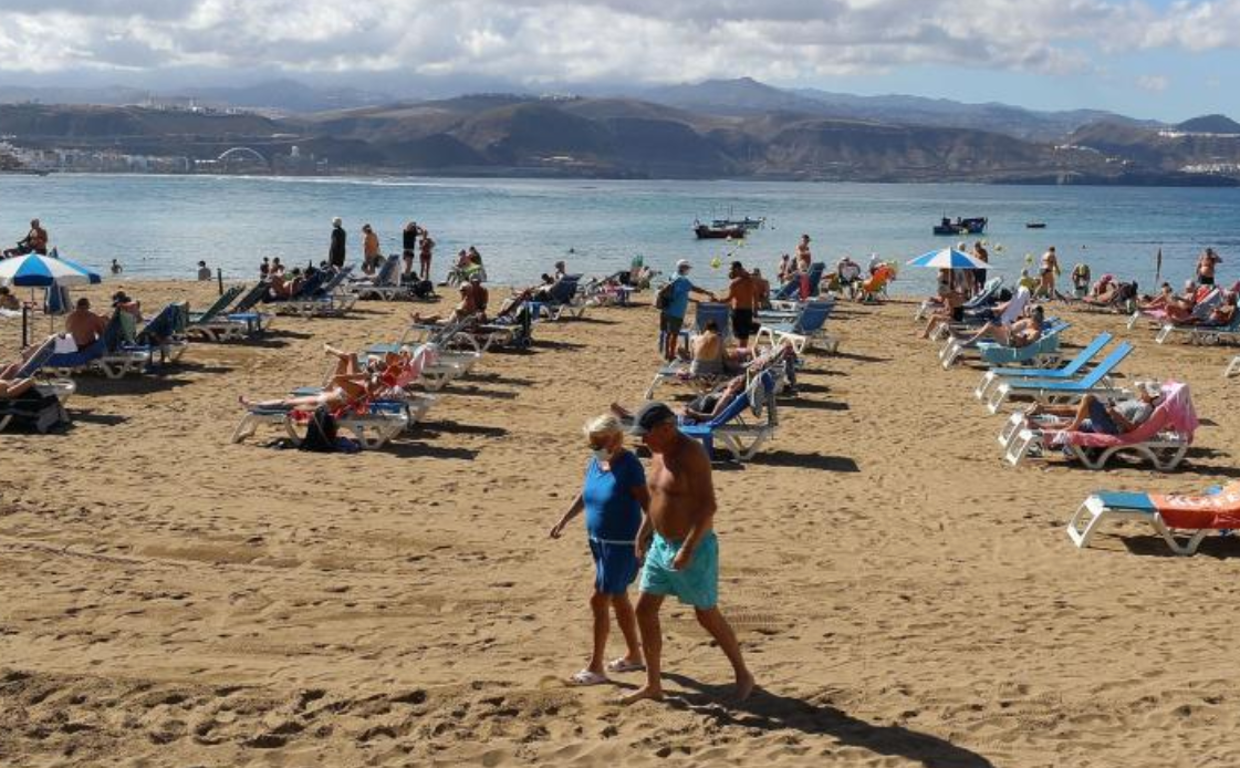 Unos turistas pasean por la playa de Las Canteras, en Gran Canaria