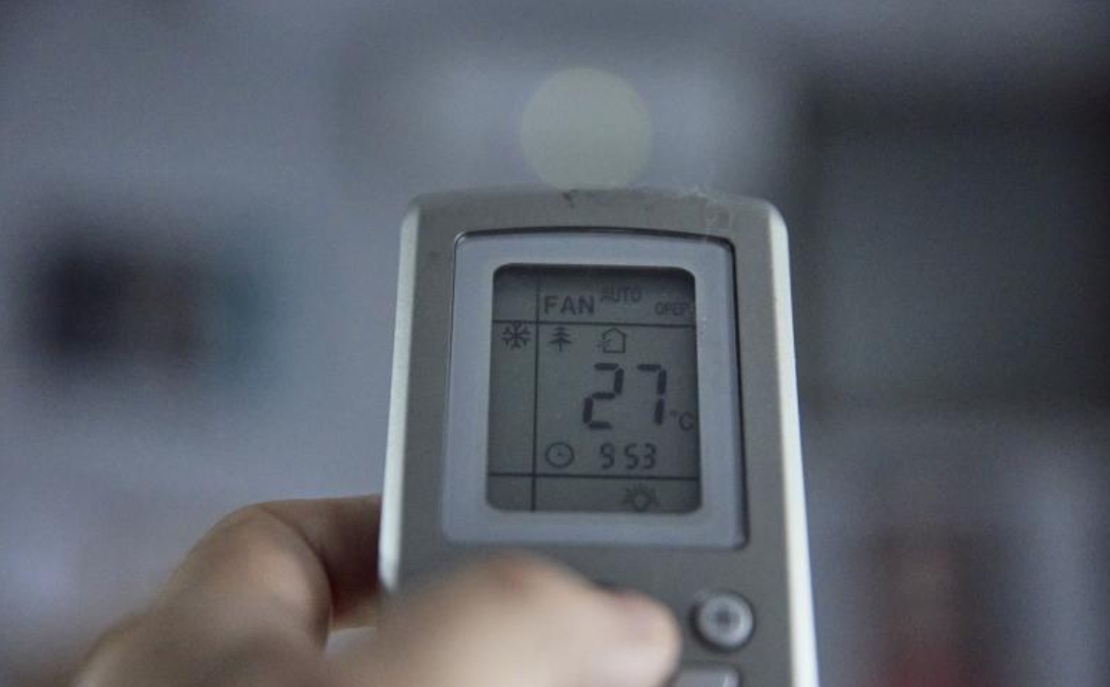 Un usuario  sube la temperatura del aire acondicionado en foto de archivo