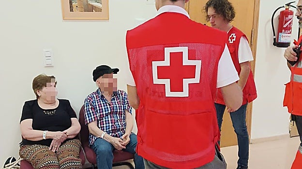 Personal de la Cruz Roja junto a desalojados por el incendio de Vall d'Ebo, en el albergue de Pego