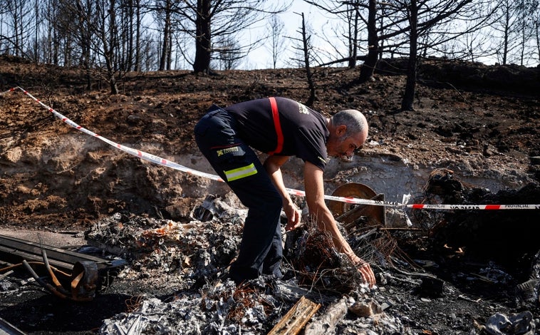 Imagen principal - Arriba, José David inspecciona los restos del camión calcinado. Abajo, Andrés posa con el uniforme ante un paisaje desolador 