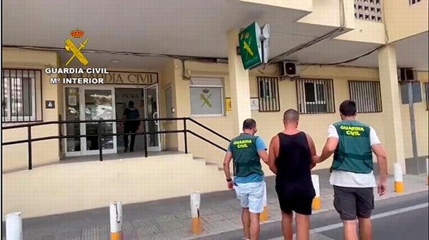 Uno de los dos detenidos, custodiado por la Guardia Civil