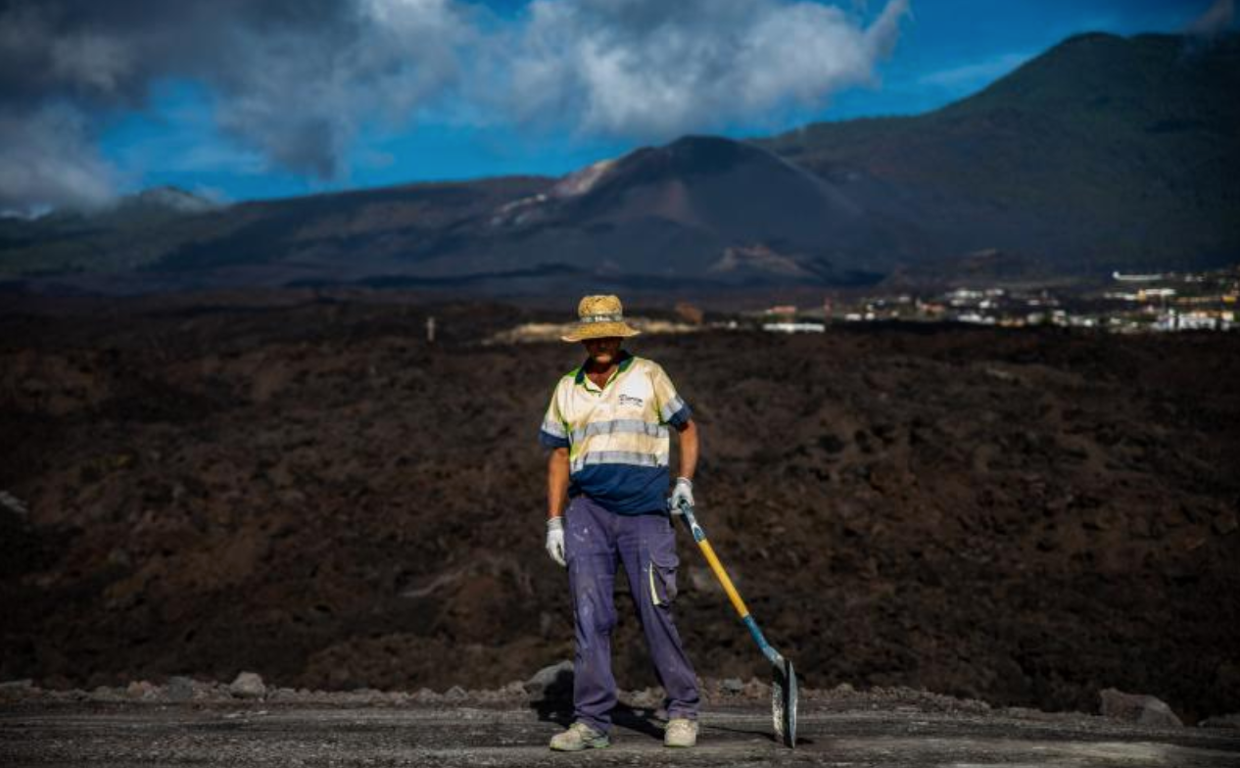 Un operario trabaja en la carretera sobre las coladas que une norte y sur de La Palma