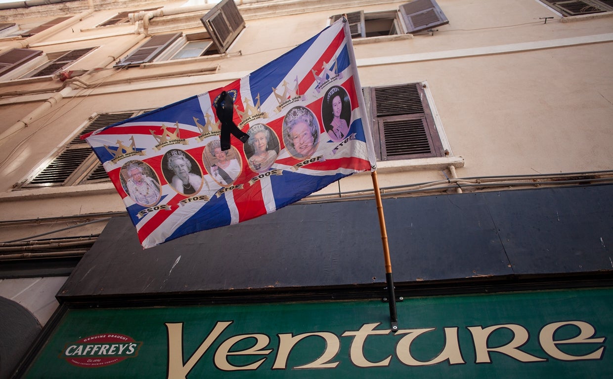 Bandera con fotos de la Reina Isabel II con un crespón negro en señal de duelo en Gibraltar