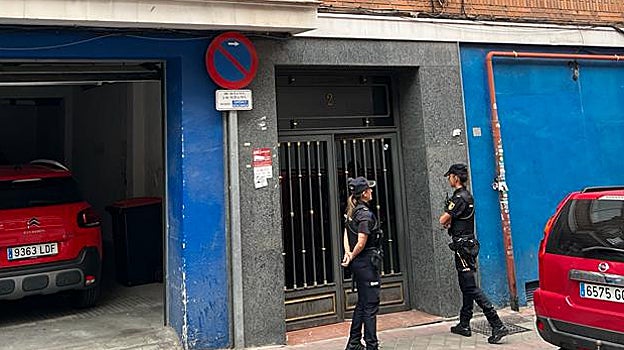 Dos policías nacionales custodian el portal donde se ha producido el registro, en la calle Boldano