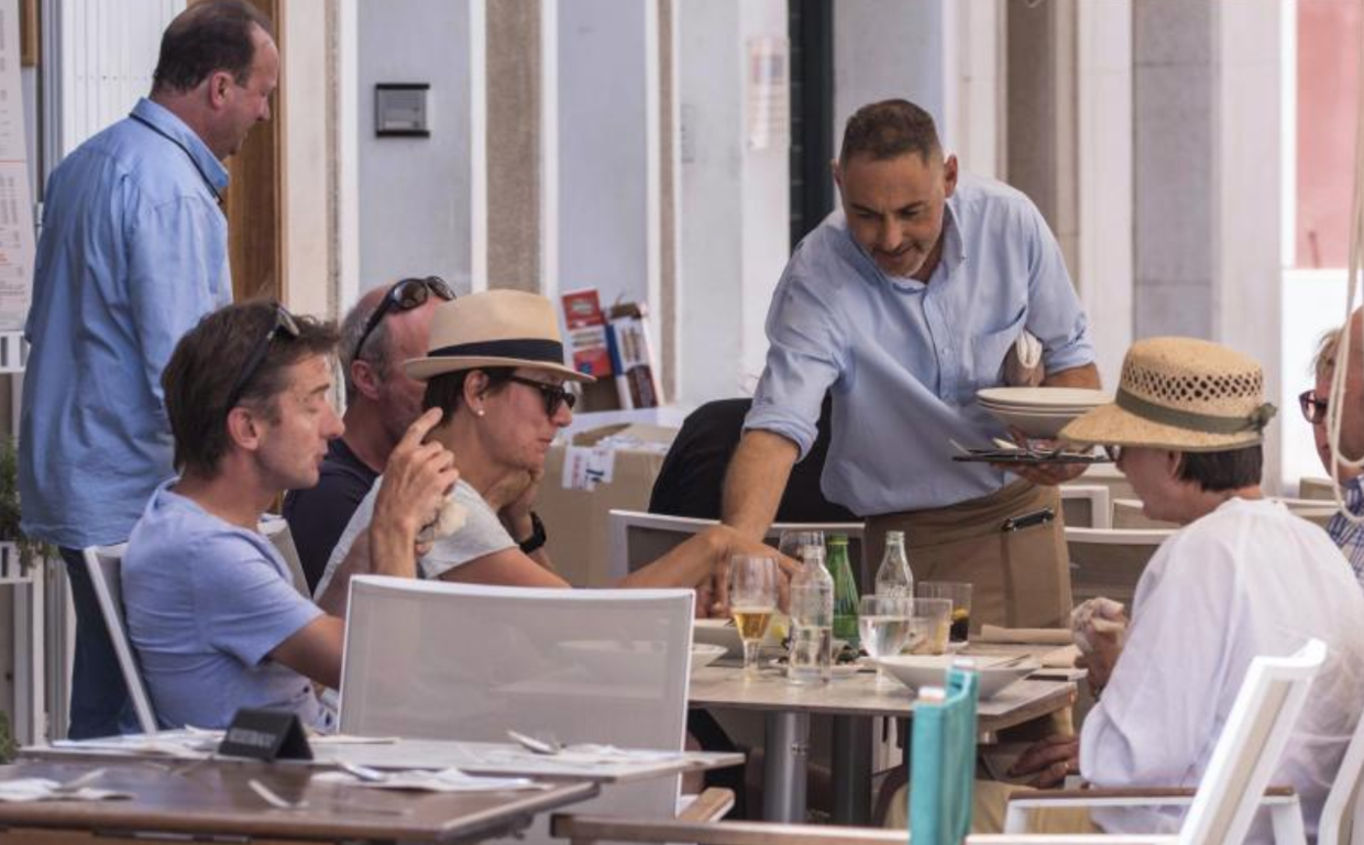 Un camarero atiende una mesa en Mahón en foto de archivo