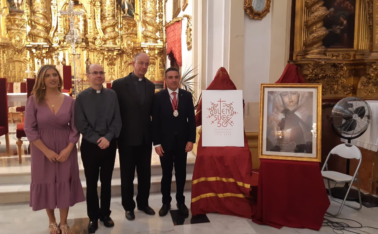 Carmen Bernal, con los sacerdotes José Luis Moreno, Pablo Calvo y el hermano mayor, junto al logo y el cartel