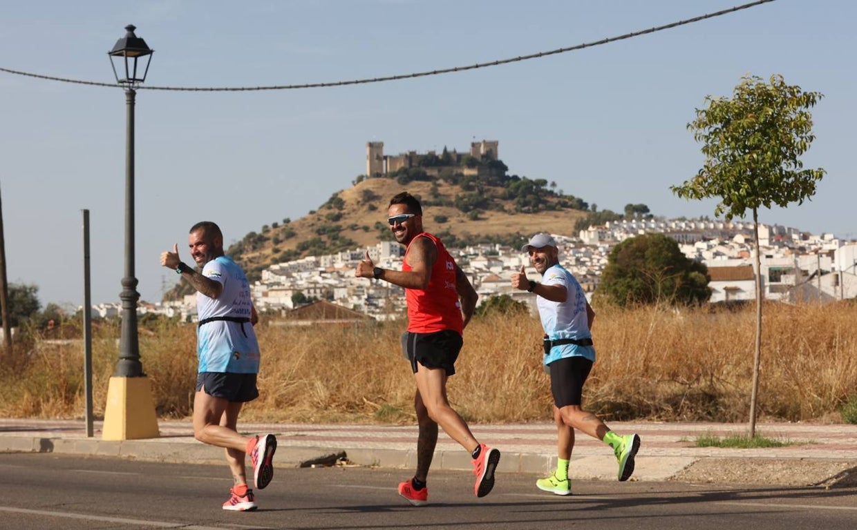 Varios atletas saludan en la prueba, con el castillo de Almodóvar al fondo
