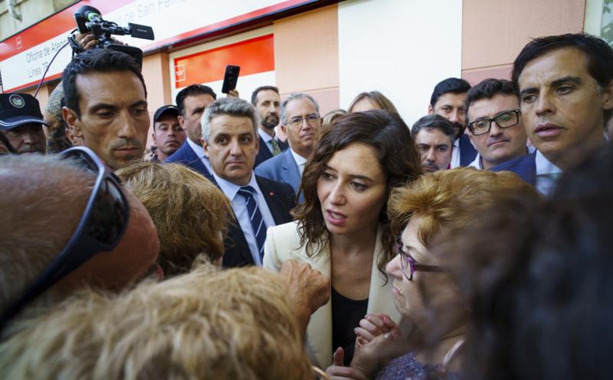 Ayuso habla con algunos de los vecinos afectados por el Metro de San Fernando