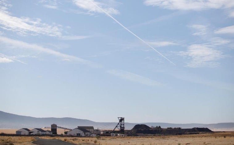 Imagen principal - Arriba, instalaciones extractivas abandonadas en la aldea peñarriblenese de El Porvenir de la Industria, en el Guadiato, donde ya no trabajan mineros; a la izquierda, niños de vacaciones en Los Blázquez, en la misma comarca, juegan con su madre en un parque infantil de este pequeño pueblo de 700 habitantes que llegaron a ser 2.000 en la década de los 50; a la derecha, un camión de paja entra a Villanueva de Córdoba, el único municipio del norte de Córdoba con conexión regular por tren, pero muy pocas frecuencias y sólo por AVE