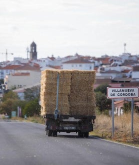 Imagen secundaria 2 - Arriba, instalaciones extractivas abandonadas en la aldea peñarriblenese de El Porvenir de la Industria, en el Guadiato, donde ya no trabajan mineros; a la izquierda, niños de vacaciones en Los Blázquez, en la misma comarca, juegan con su madre en un parque infantil de este pequeño pueblo de 700 habitantes que llegaron a ser 2.000 en la década de los 50; a la derecha, un camión de paja entra a Villanueva de Córdoba, el único municipio del norte de Córdoba con conexión regular por tren, pero muy pocas frecuencias y sólo por AVE