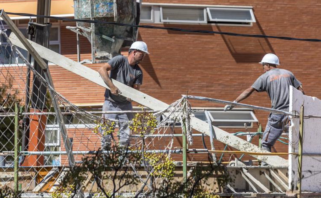 Unos albañiles trabajan en la reforma de un edificio de viviendas