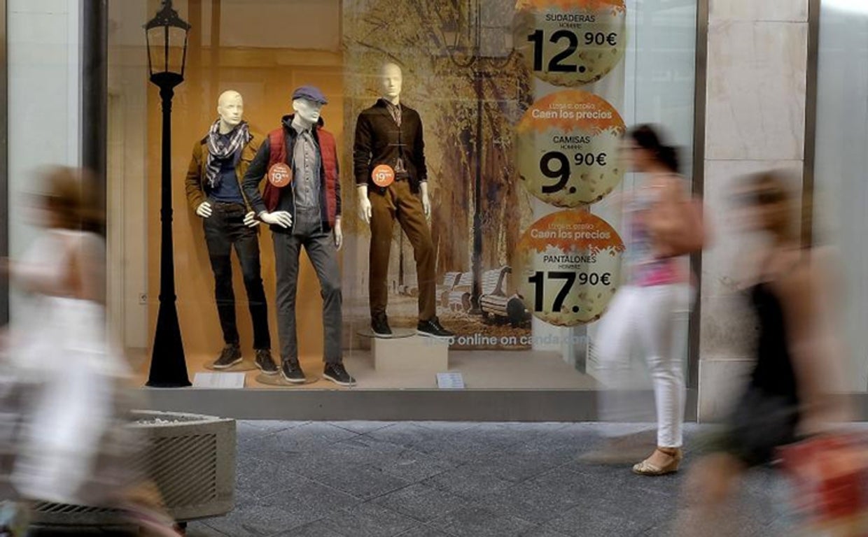 Fotografía de archivo de viandantes pasando por delante del escaparate de una tienda