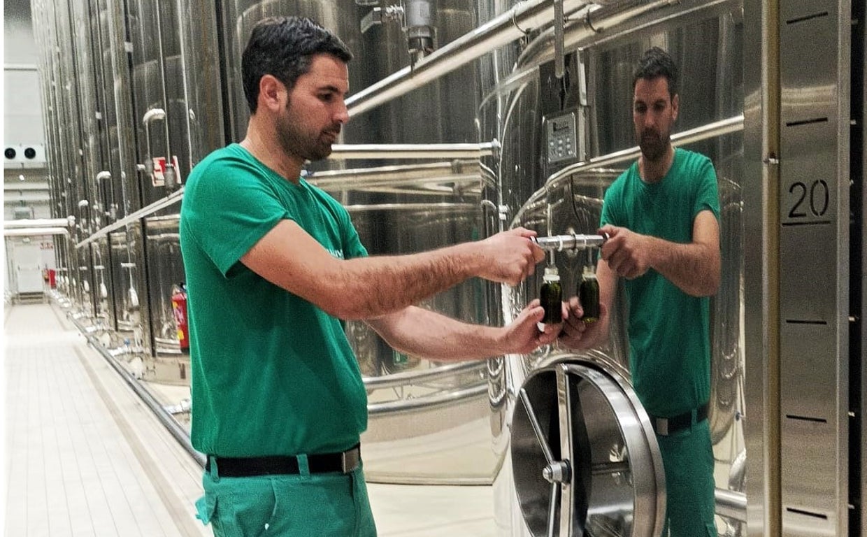 Carlos García extrae una muestra de un tanque de la bodega de Almazaras de la Subbética