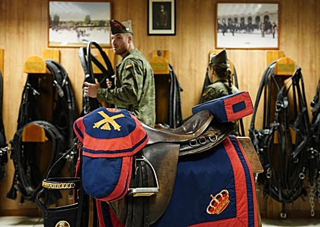 Imagen secundaria 1 - En la imagen superior y sobre estas líneas, a la izquierda, artilleros de la Batería Real equipando a un caballo hispano bretón de la Sección Hipomóvil. Grupo de Escoltas. A la derecha, Sección de Guías de Perros, perteneciente a la Compañía de Control Militar, Grupo de Escoltas.
