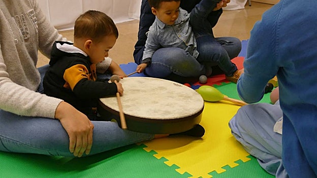 NIños practicando con instrumentos musicales, durante el taller
