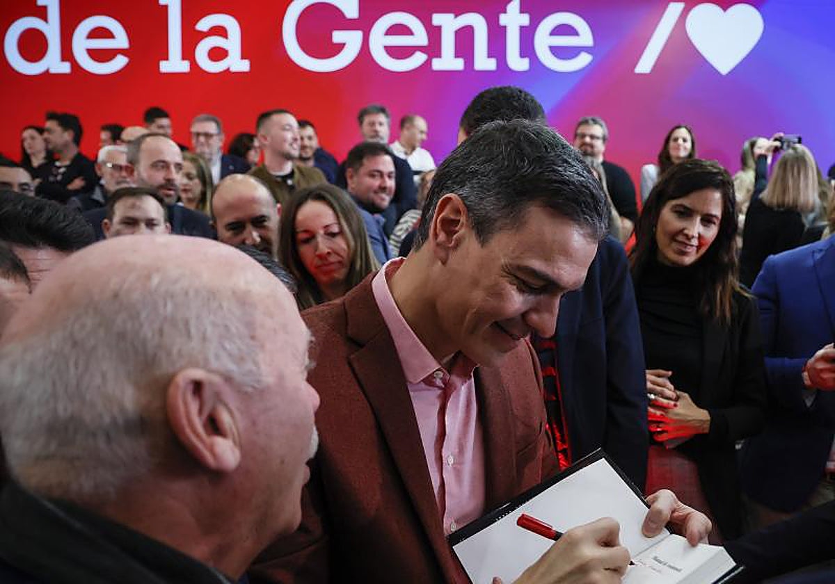 Pedro Sánchez firma un ejemplar de su libro, 'Manual de resistencia', en un acto este sábado en Valencia