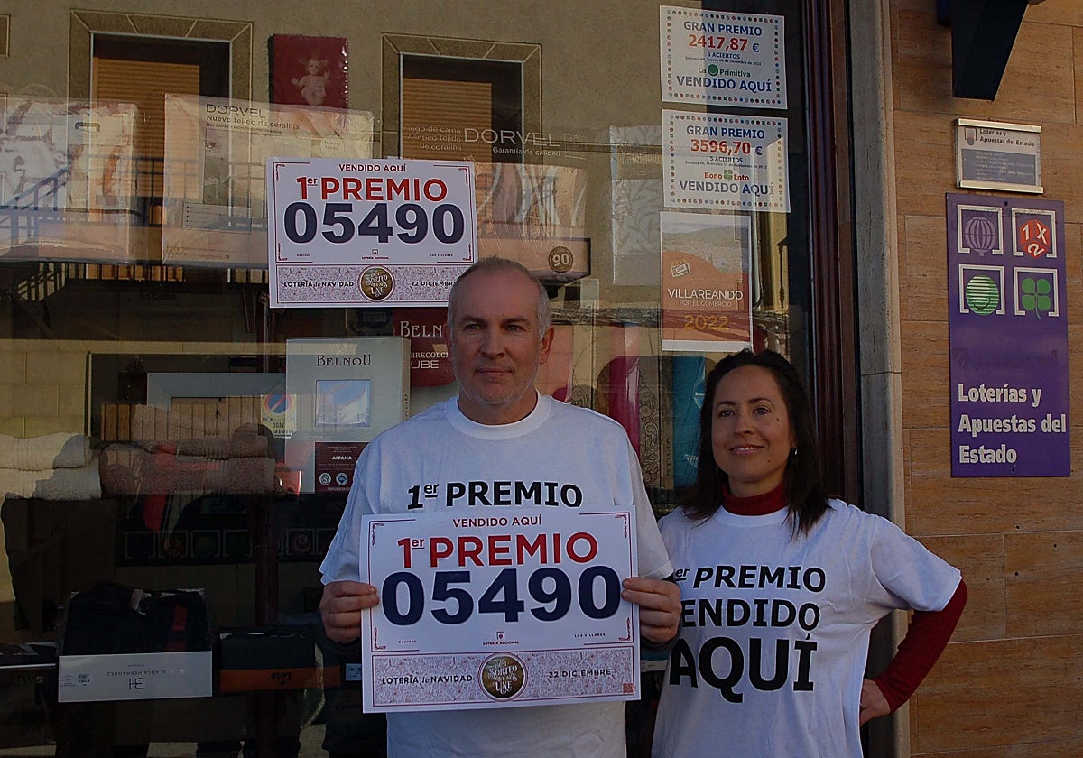 Los propietarios de la administración de lotería de Los Villares exhiben el cartel del Gordo de Navidad