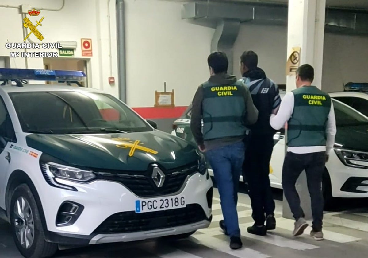 Uno de los detenidos, custodiado por la Guardia Civil.