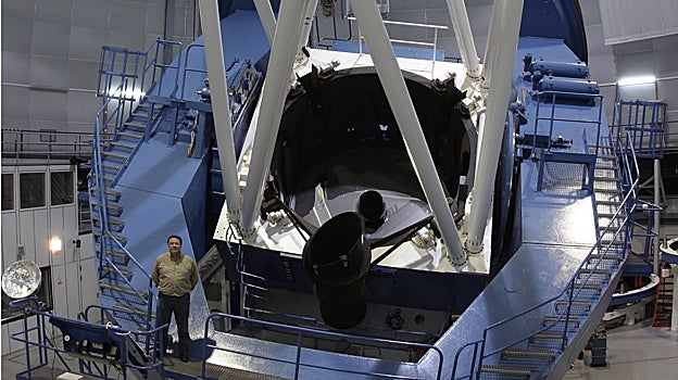 Un profesional del observatorio, junto al mayor de los telescopios