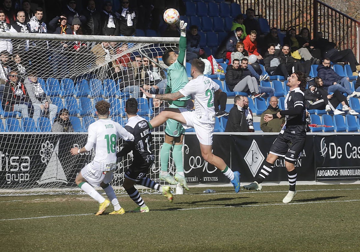Simo y Casas buscan el remate en el área de Unionistas en un despeje del portero local