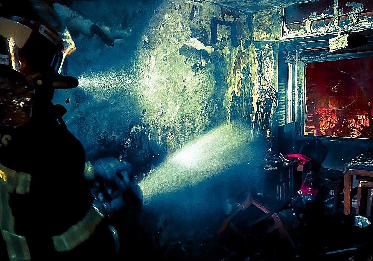 Los bomberos terminan de extinguir el incendio en el salón de la vivienda