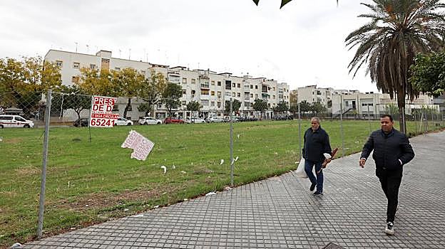 Varias personas pasan delante del solar del Pabellón de la Juventud, en el Sector Sur