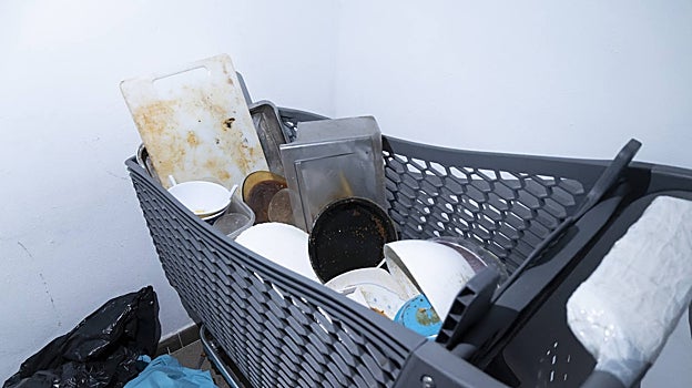 Un carro con sartenes y platos llenos de comida pegada