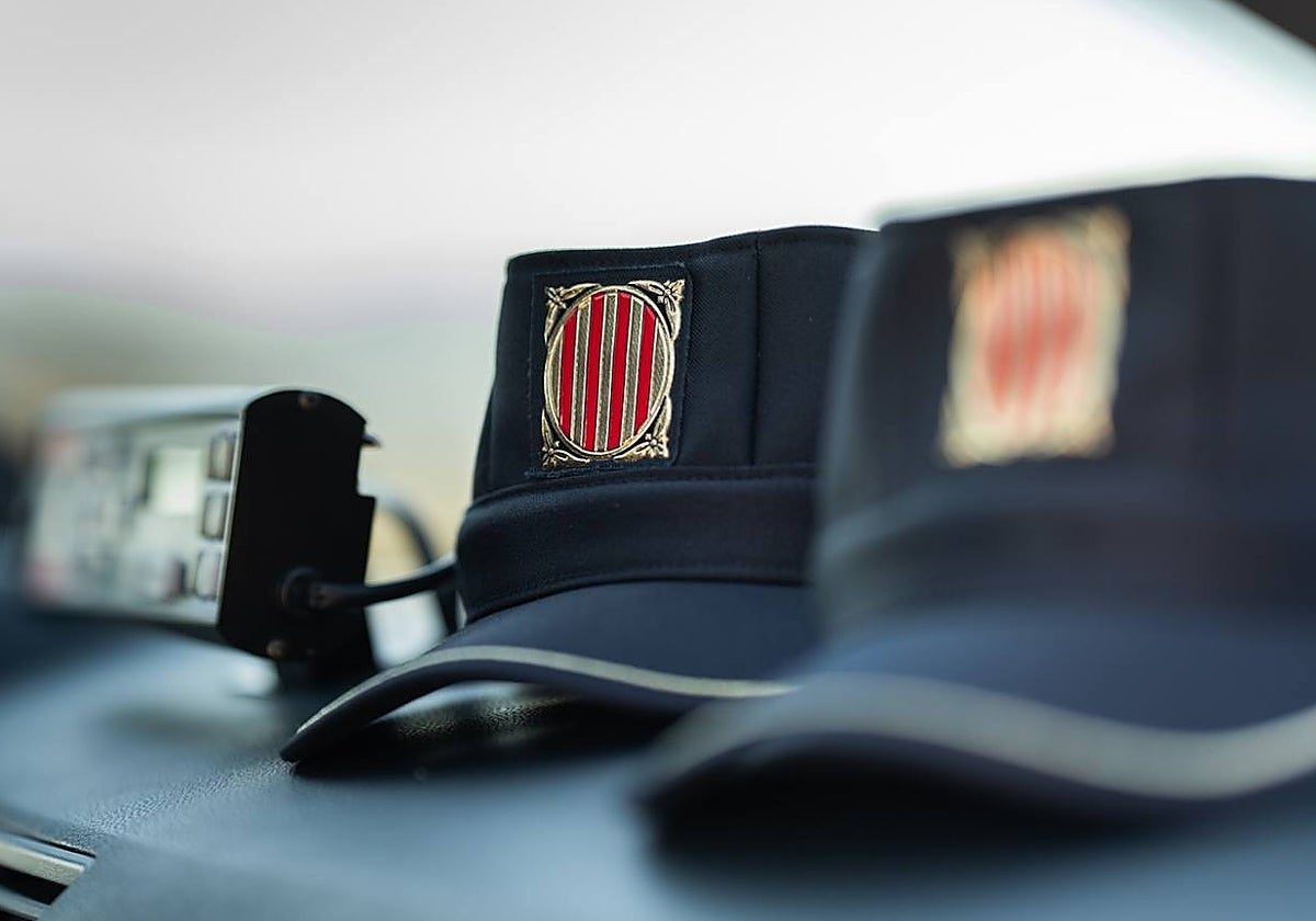 Interior de un coche patrulla de la Policía catalana, con dos gorras de los agentes