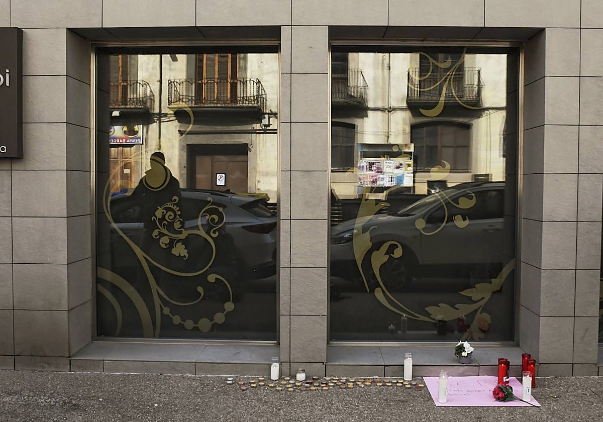 Imagen de la entrada del edificio en que vive la familia, con velas y una pancarta de homenaje