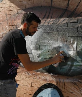 Imagen secundaria 2 - El artista David Barrera ha pintado las fachadas de la oficina con la ayuda de las personas a las que presta servicio; en grande, el grafiti de Daniel Díaz, el impulsor del proyecto