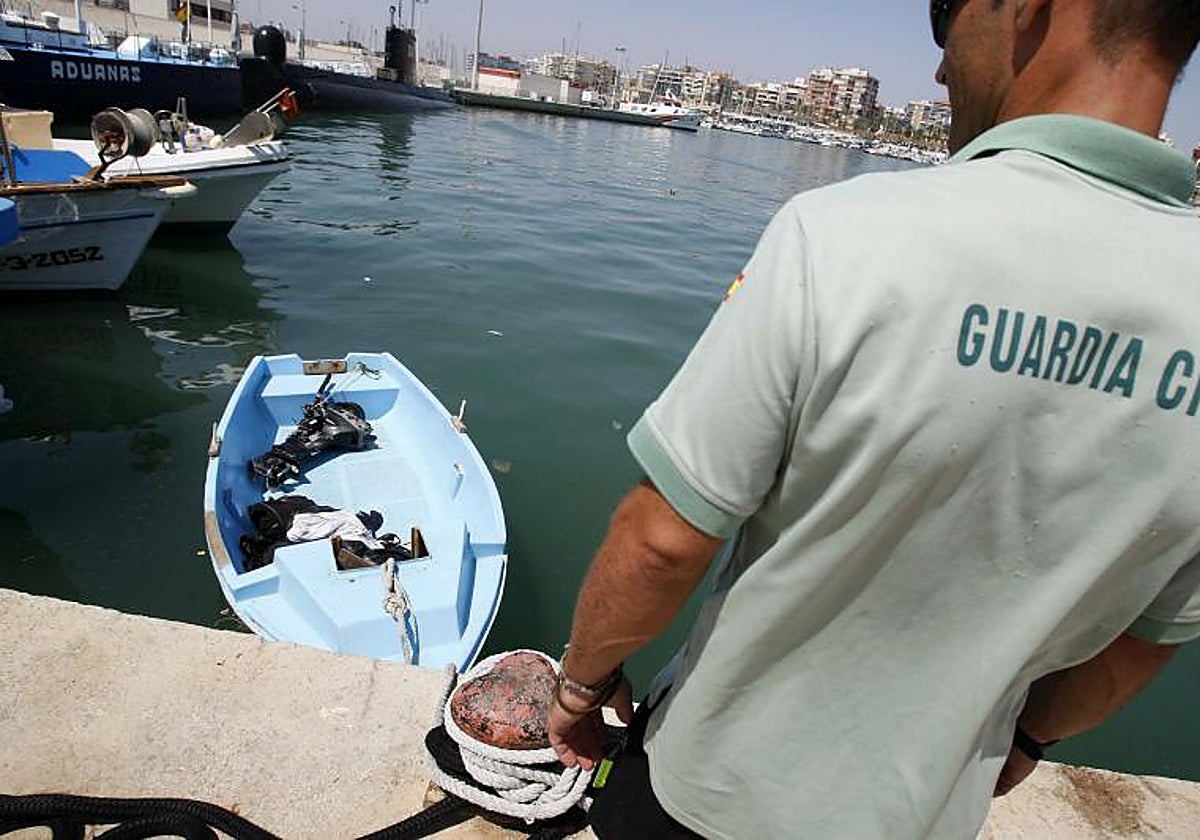 Personal de Salvamento Marítimo observa una patera interceptada en aguas alicantinas, en imagen de archivo.
