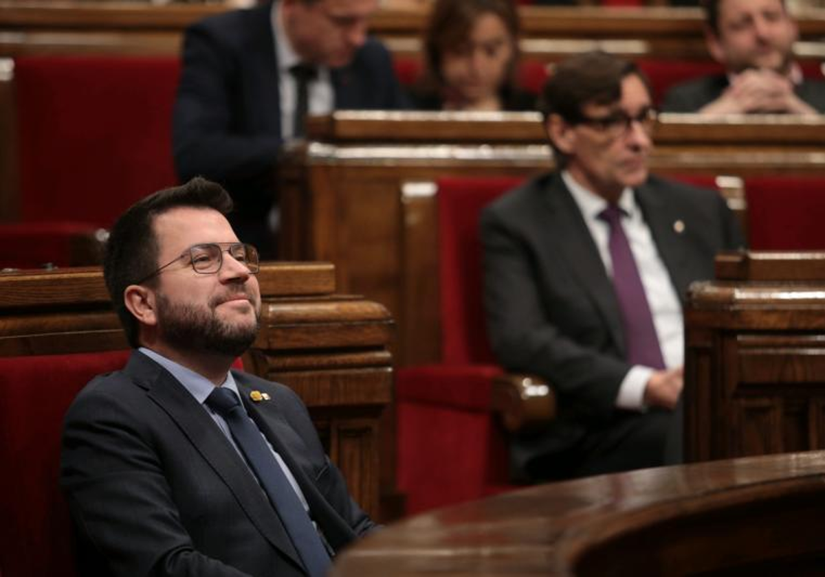 Pere Aragonès, presidente de la Generalitat, en primer plano, y Salvador Illa, líder del PSC, hoy, en el Parlamento de Cataluña