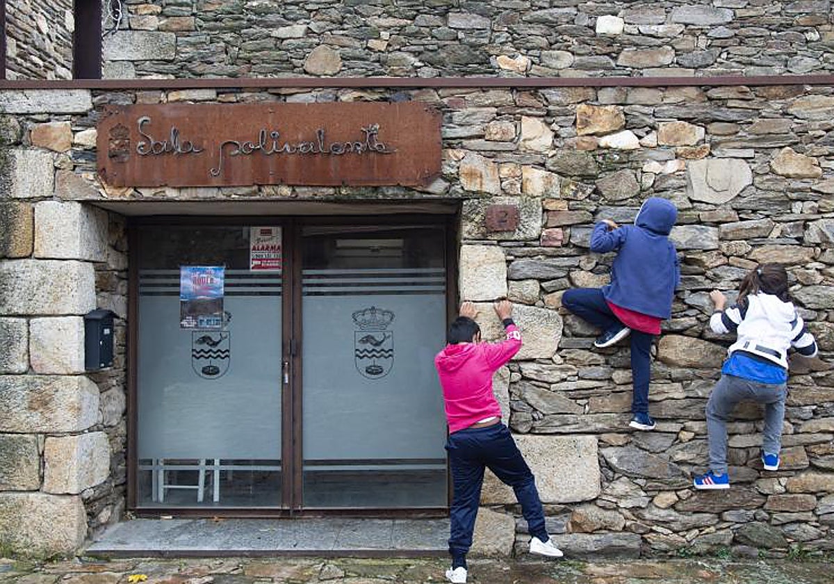 Varios niños juegan en la puerta de la Sala Polivalente de Madarcos, un municipio madrileño con 58 vecinos
