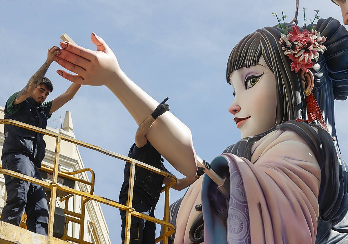 Imagen de dos trabajadores avanzando en la plantà de las Fallas de Valencia